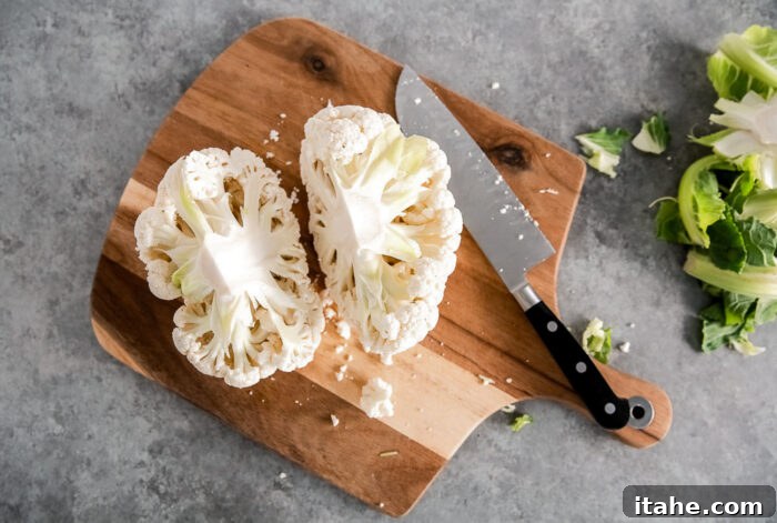 Crispy Roasted Air Fryer Cauliflower 5 Cauliflower head cut in half on a wooden board, showing the central core.