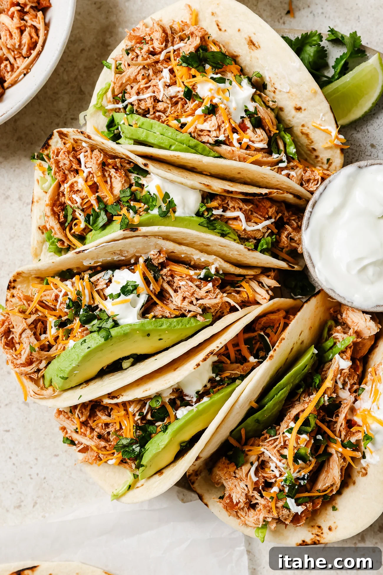 Slow Cooker Chicken Tacos with fresh toppings on a kitchen countertop.