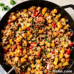 Overhead view of ground beef and potatoes cooked in a cast-iron skillet.