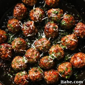 Sticky Honey Garlic Meatballs with Soy Glaze 10 A pan filled with Honey Garlic Meatballs, glazed to perfection and garnished with chopped herbs and grated cheese.