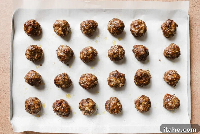 Sticky Honey Garlic Meatballs with Soy Glaze 5 baked meatballs on a baking sheet